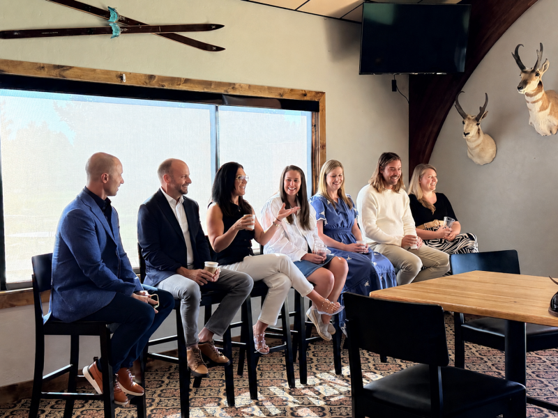 Seven people sitting in a row during a business meeting.