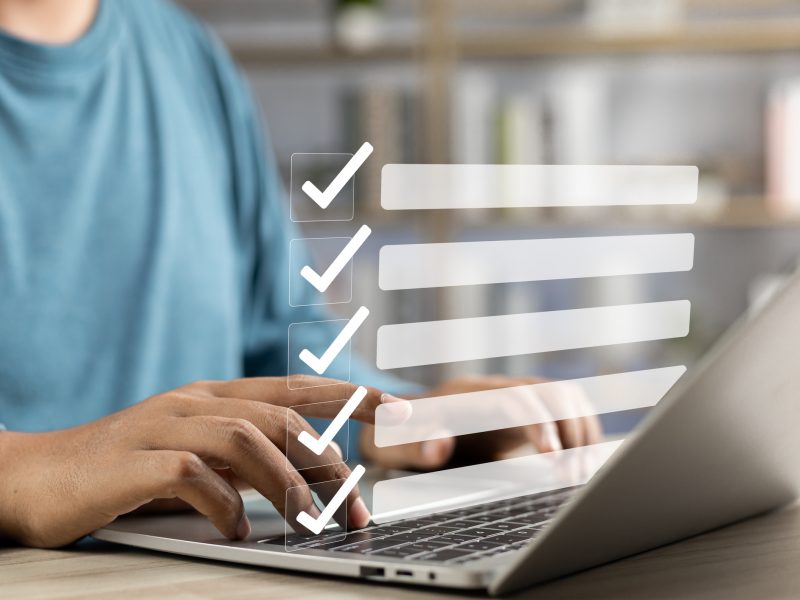 Business performance monitoring and evaluation concept, Take an assessment, Business man using laptop and tablet online checklist survey, Filling out digital checklist, Questionnaire with checkboxes.